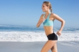 Fit woman jogging on the beach on a sunny day