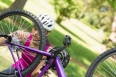 Young woman in helmet trying to fix a chain on mountain bike in the park