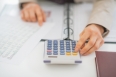 Closeup on business woman using calculator