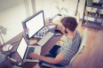 Casual young businessman using computers in office