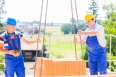 Construction site worker building house with crane